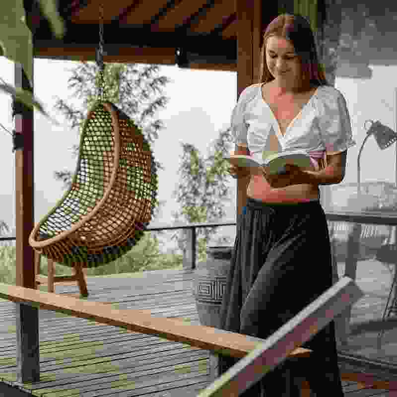 Beautiful woman reading a book in her vacation home in Colombia.