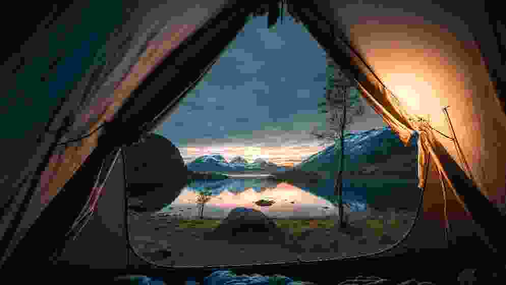 Looking out at the rocky mountains from inside a warm, cozy tent.