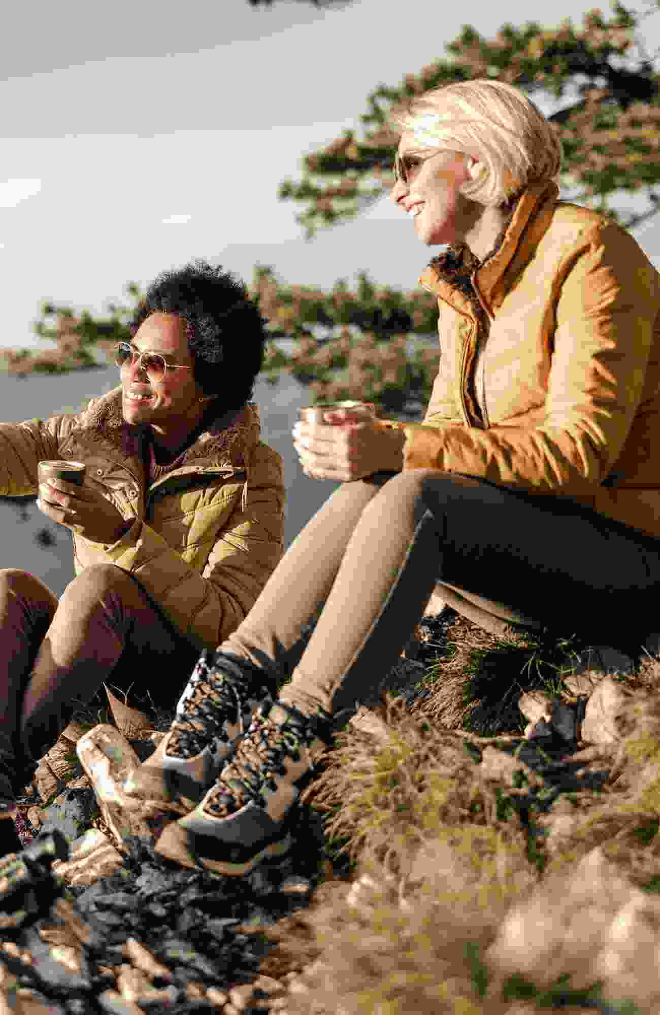 Two lady friends discuss their vacation plans over a cup of coffee.