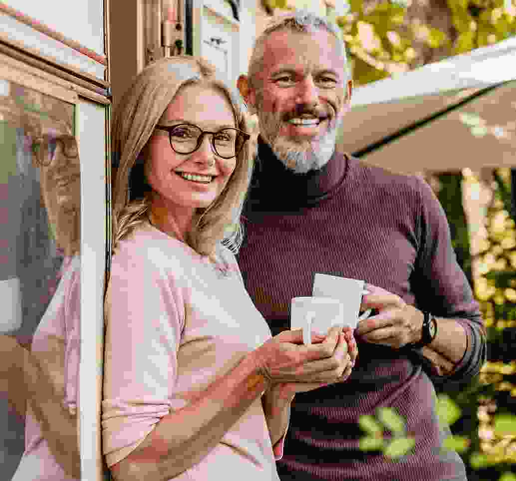 Middle-aged couple drinks coffee while plaining their vacation in Colombia.