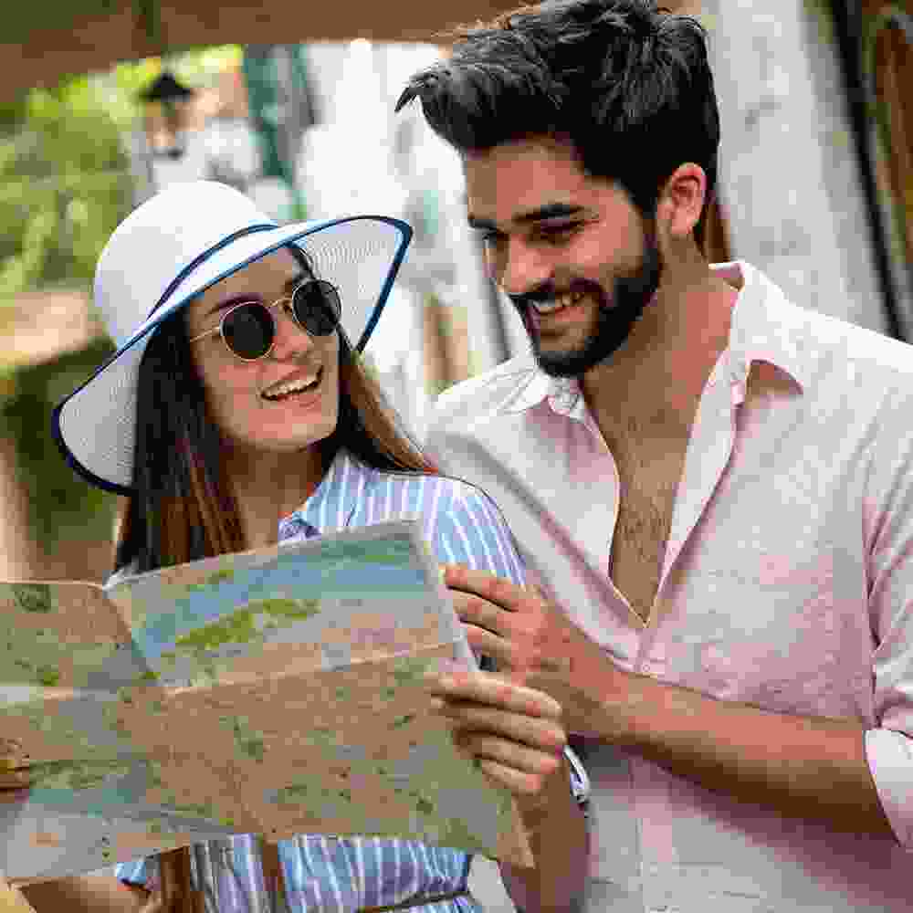 Elated vacationing couple consult a map to find their way to their next destination.