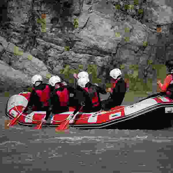 Group of friends rafting with guide in the wilderness.