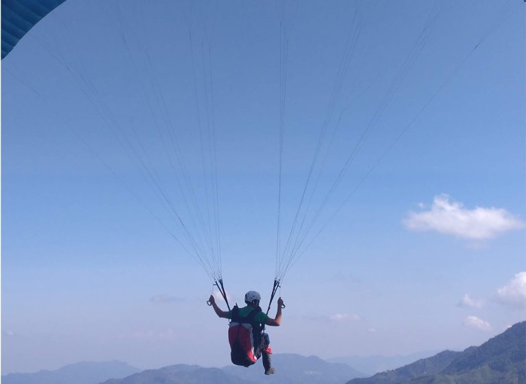 Gliding through clear skies during a Colombian paragliding trip.