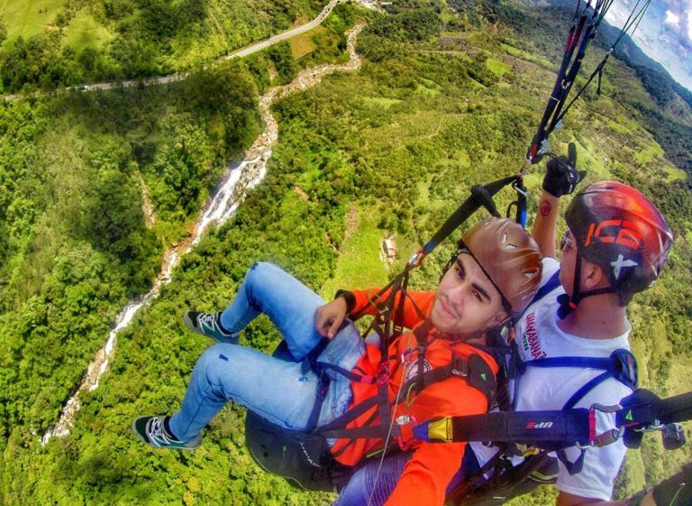 Paragliding over misty mountain ranges in Colombia.